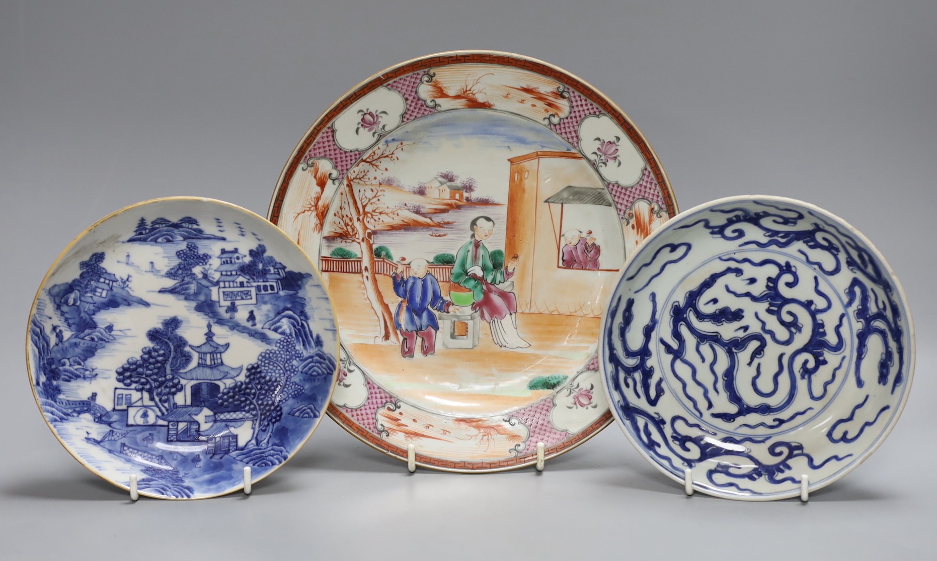 An 18th century Chinese export famille rose plate and two similar blue and white saucers, largest 23cm